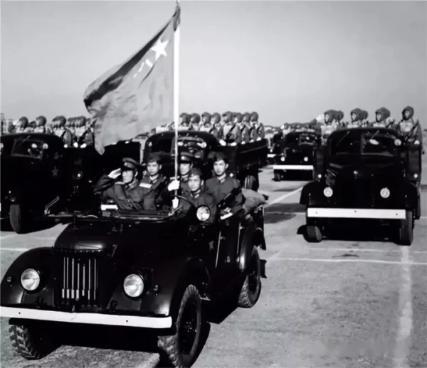 1956年国庆阅兵，身着55式军服的中国人民解放军伞兵方队接受检阅。前方引导车为嘎斯69（GAZ-69A）驾驶员头戴苏式船型帽
后方运兵车辆为新中国第一辆汽车——CA110型解放牌汽车。