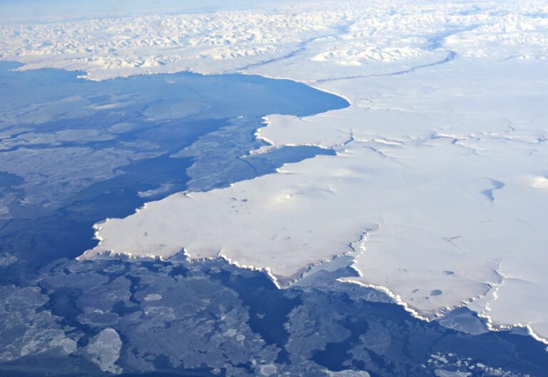 高空俯瞰深蓝海面上覆盖着大片白色冰雪