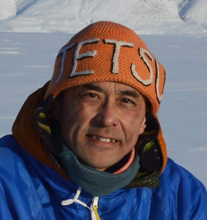 戴橙色JETS帽穿蓝衣的男子身处雪地