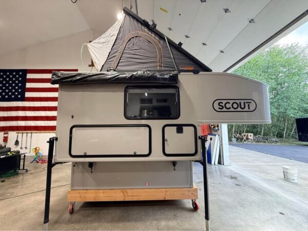 灰色Scout房车停在车库内并升起车顶帐篷
