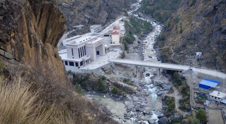 灰白建筑群矗立于山间河流旁