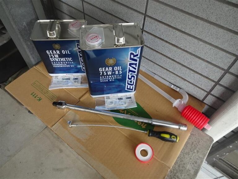 银色齿轮油桶与换油工具摆放在纸箱上