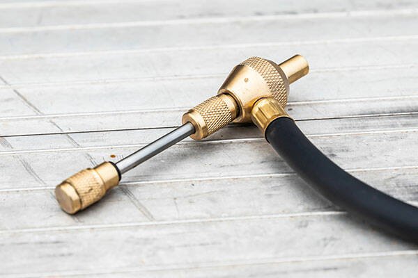 黄铜充气接头与黑色软管置于木纹桌面