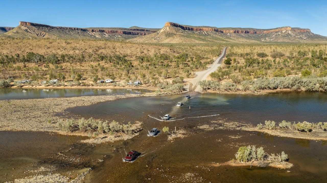 多辆越野车在干旱荒野的浅水路段涉水行驶