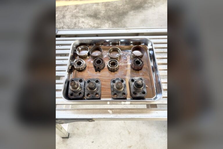银色托盘内摆放着拆解的金属轴承零件