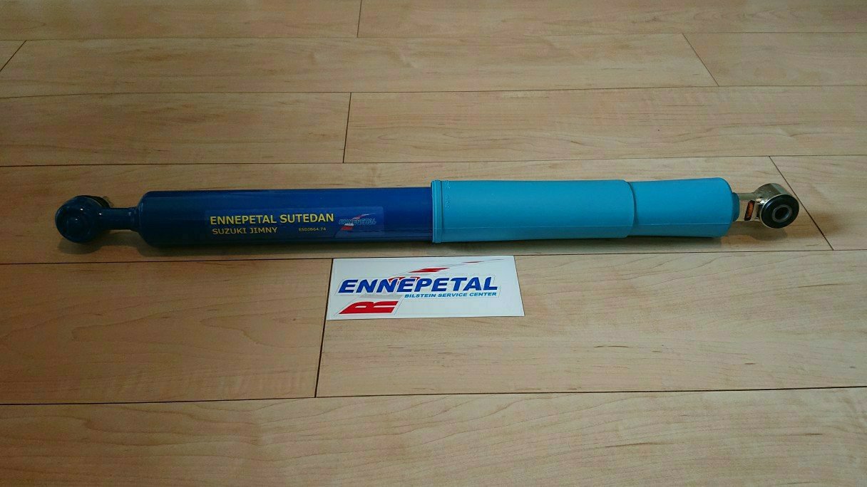 木地板上放置的蓝色ENNEPETAL铃木吉姆尼减震器