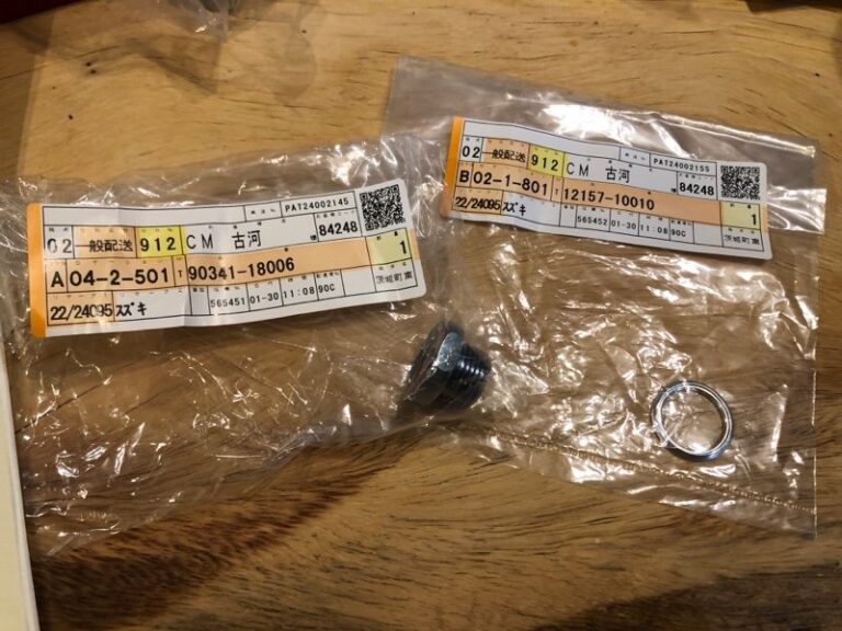 木桌上放着两个装有金属零件的透明塑料包装袋