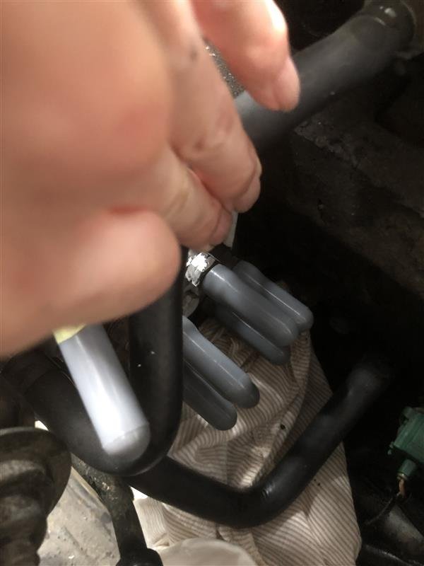 手捏黑色软管与灰色接头维修汽车