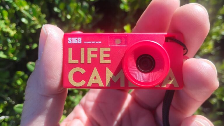 一只手在户外拿着红色LIFE CAMERA迷你相机