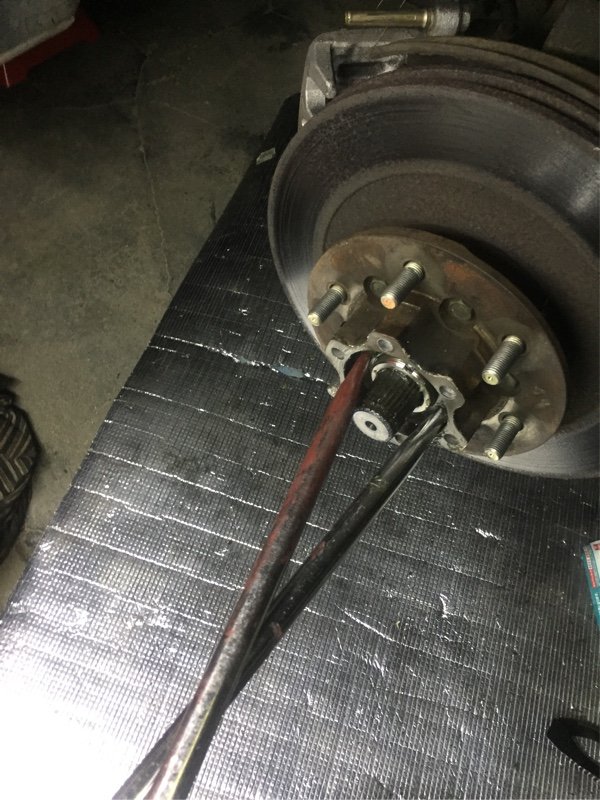 银色刹车鼓轮毂上插着红黑两色拉拔工具