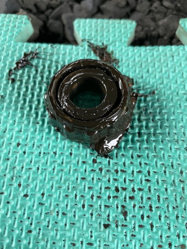 黑色油污状物体附着在绿色网格垫上