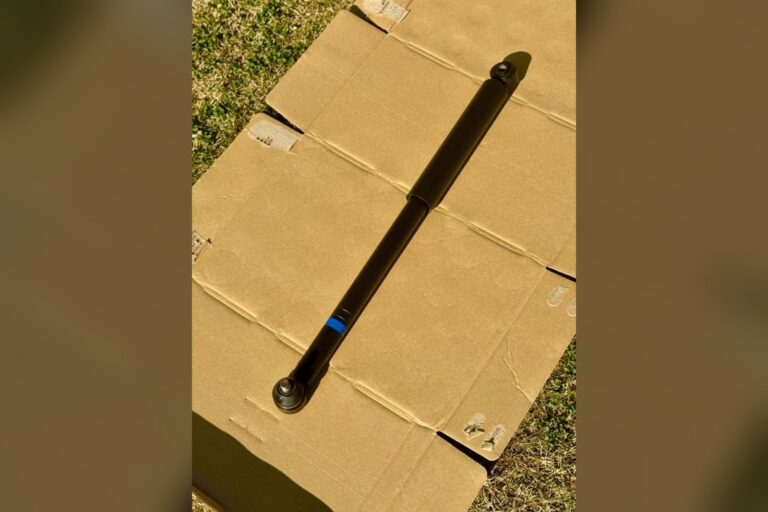 黑色汽车减震器斜放在户外纸板上