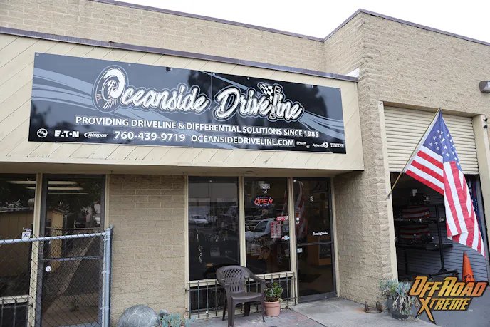 浅黄色砖墙店铺上方挂有黑色Oceanside Driveline招牌