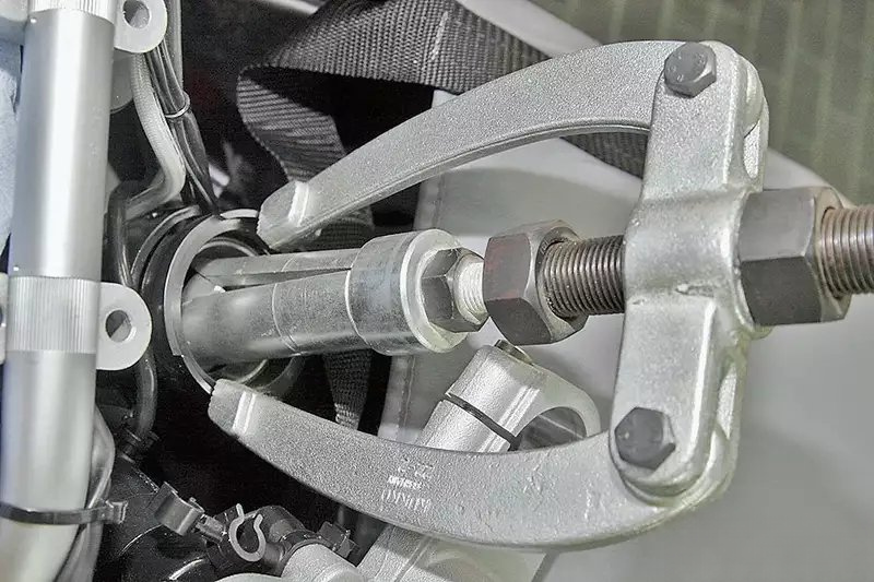 银色三爪拉马工具正在拆卸汽车金属部件